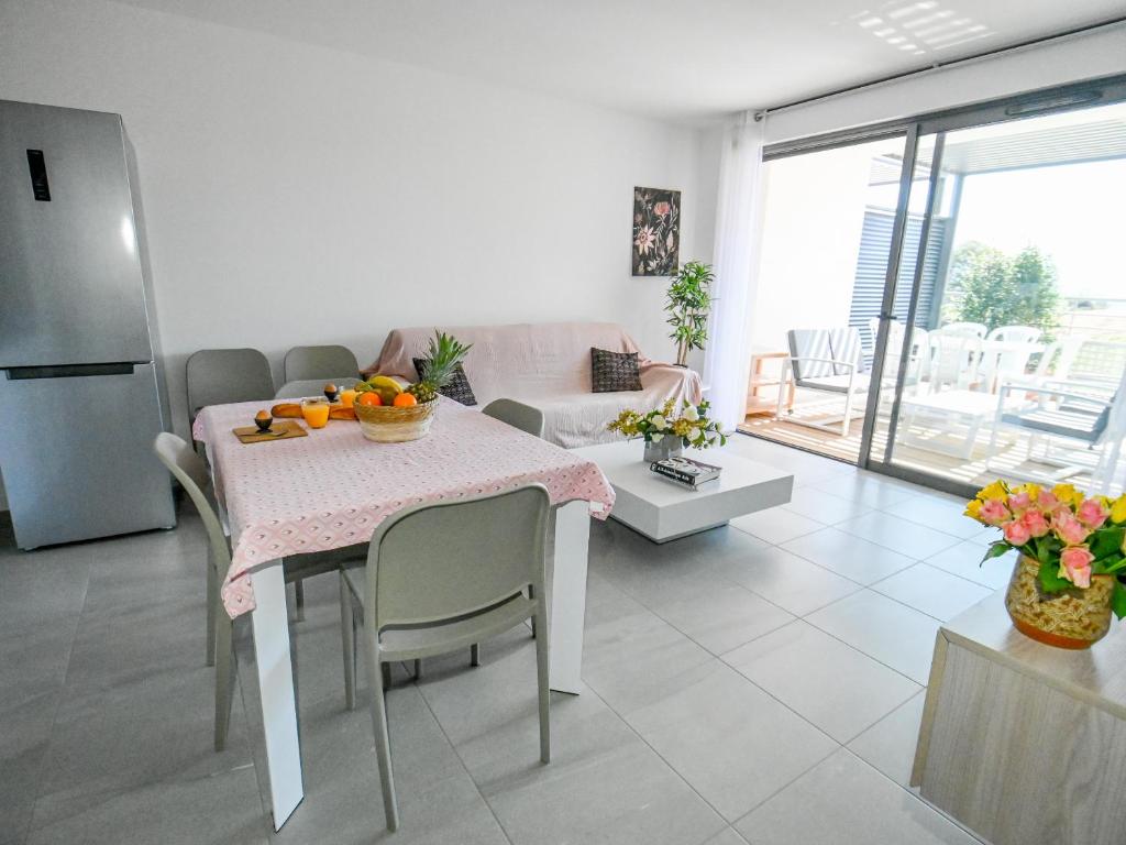 波尔蒂乔Les Vallons du Fort - Terrasse - Wifi - Clim的厨房以及带水果桌的客厅。