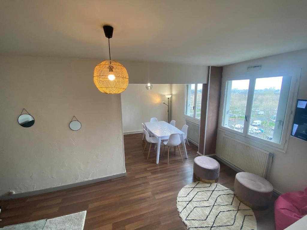克莱蒙费朗Appartement, parking gratuit, sortie, autoroute, la méridienne的客厅配有桌椅和窗户。