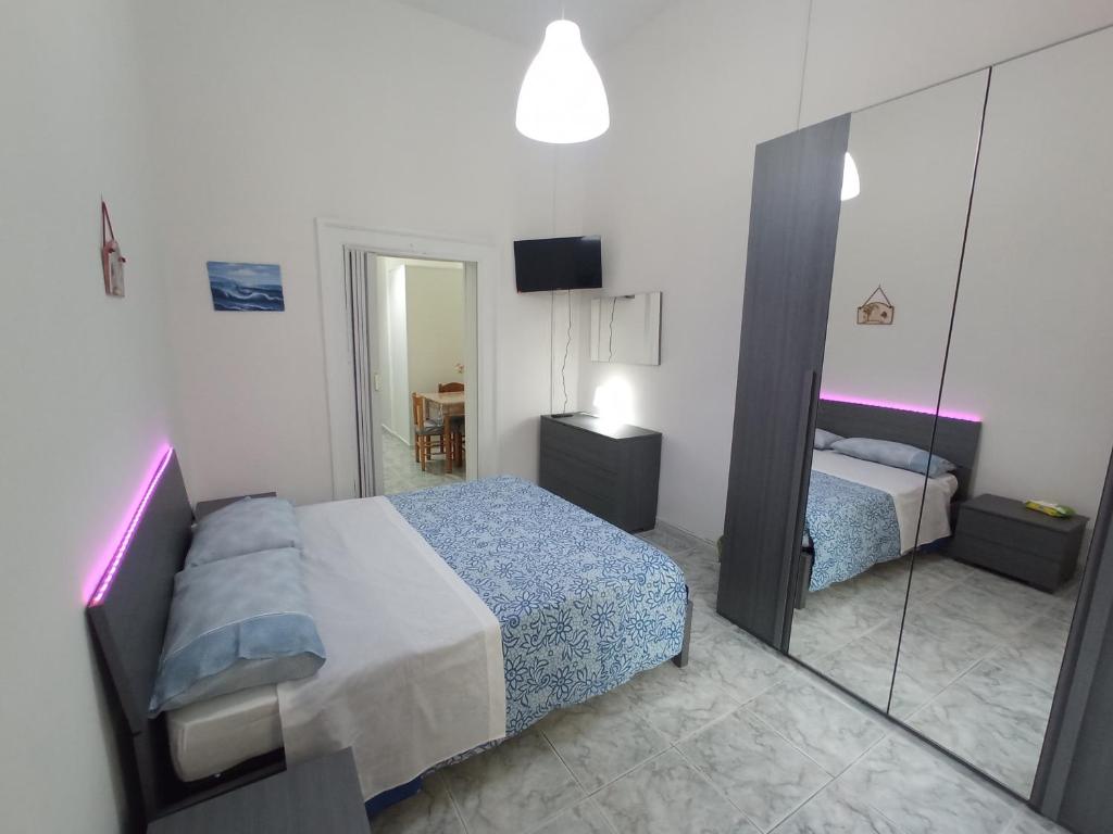 那不勒斯Flegrei Apartment的一间小卧室,配有一张床和镜子