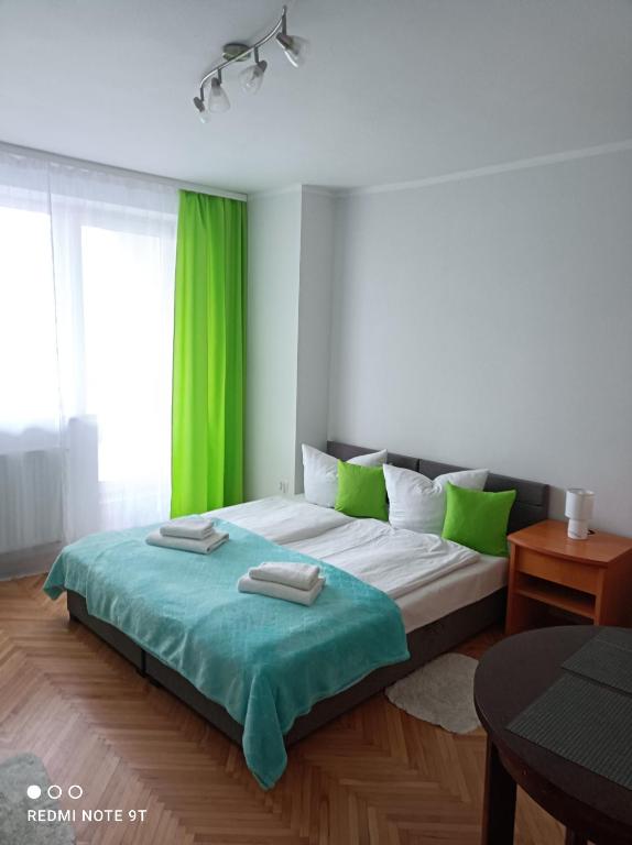斯维诺乌伊希切Dom gościnny Zosia的一间卧室配有一张带绿色窗帘的大床