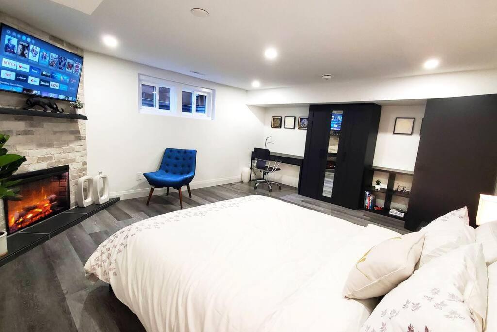 多伦多Renovated Guest Suite Near The Lake & High Park in Toronto!的卧室配有一张白色大床和壁炉