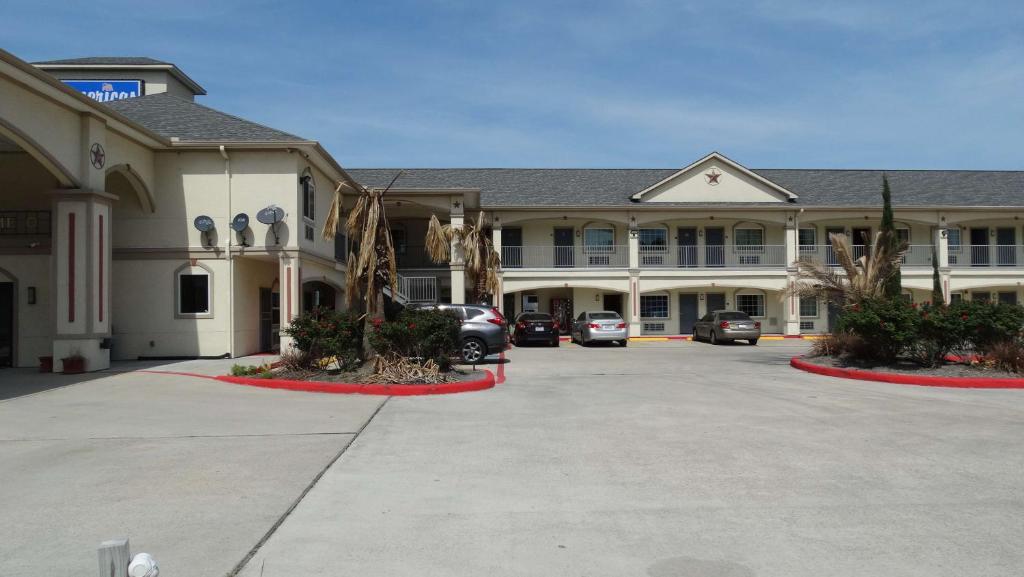 休斯顿Motel 6 Houston, TX – Willowbrook Mall的停车场内停放汽车的大型建筑