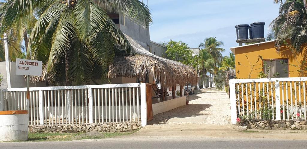 科韦尼亚斯Cabañas La Cuchita RNT 61621的棕榈树建筑旁边的白色围栏