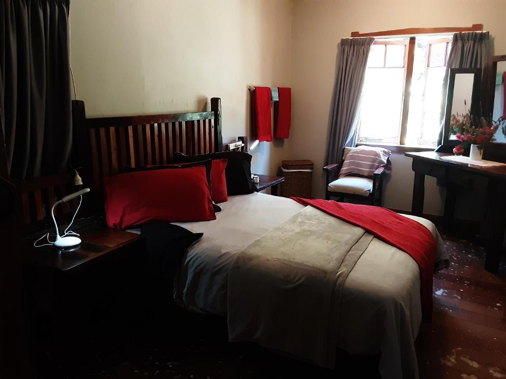 RuawaroShare our home farm stay的一间卧室配有一张带红色枕头的大床
