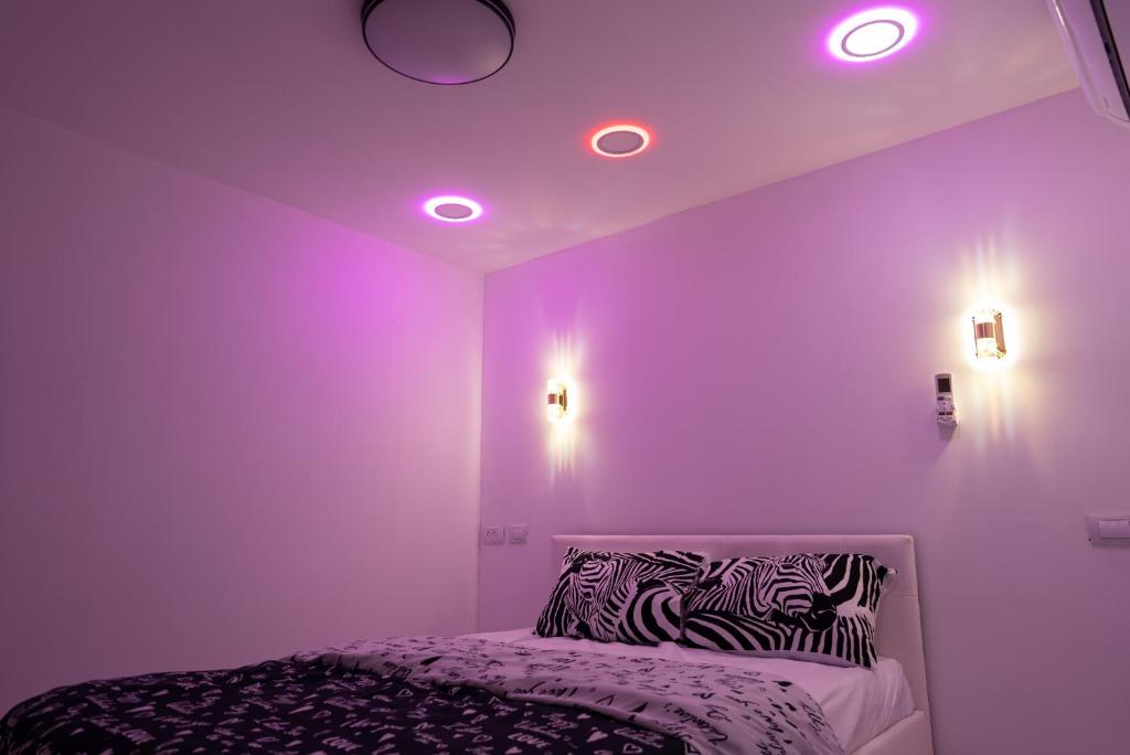 迈季代勒舍姆斯Dove Suites的紫色客房,配有带斑马枕头的床