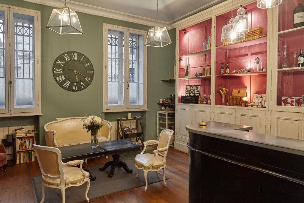 波尔多L'Hôtel Particulier Bordeaux的配有桌椅和时钟的房间