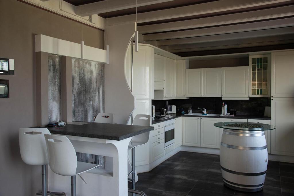 利莫内-苏尔加达Guesthouse "Villa Tamas"的厨房配有白色橱柜和桌椅