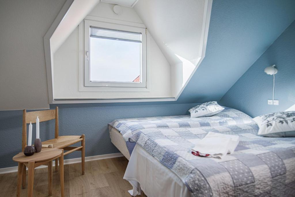 Slettestrand霍伊加登酒店的阁楼卧室设有两张床和窗户。