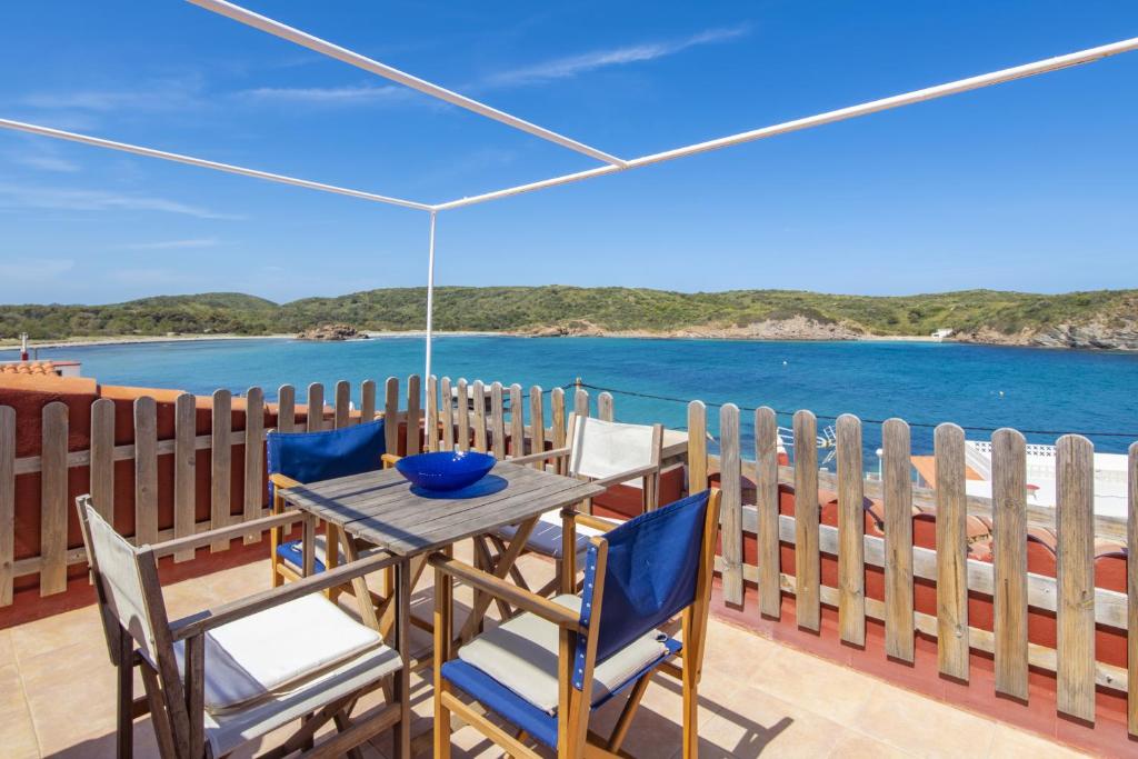 Es GrauFantástico apartamento frente al mar en Menorca的海景阳台上的桌椅