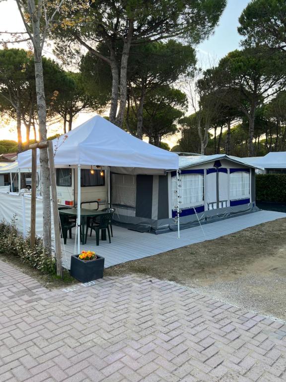 卡瓦利诺Caravan Cavallino - Valentini in Campeggio Union Lido的露台上的帐篷,配有桌子和烧烤架