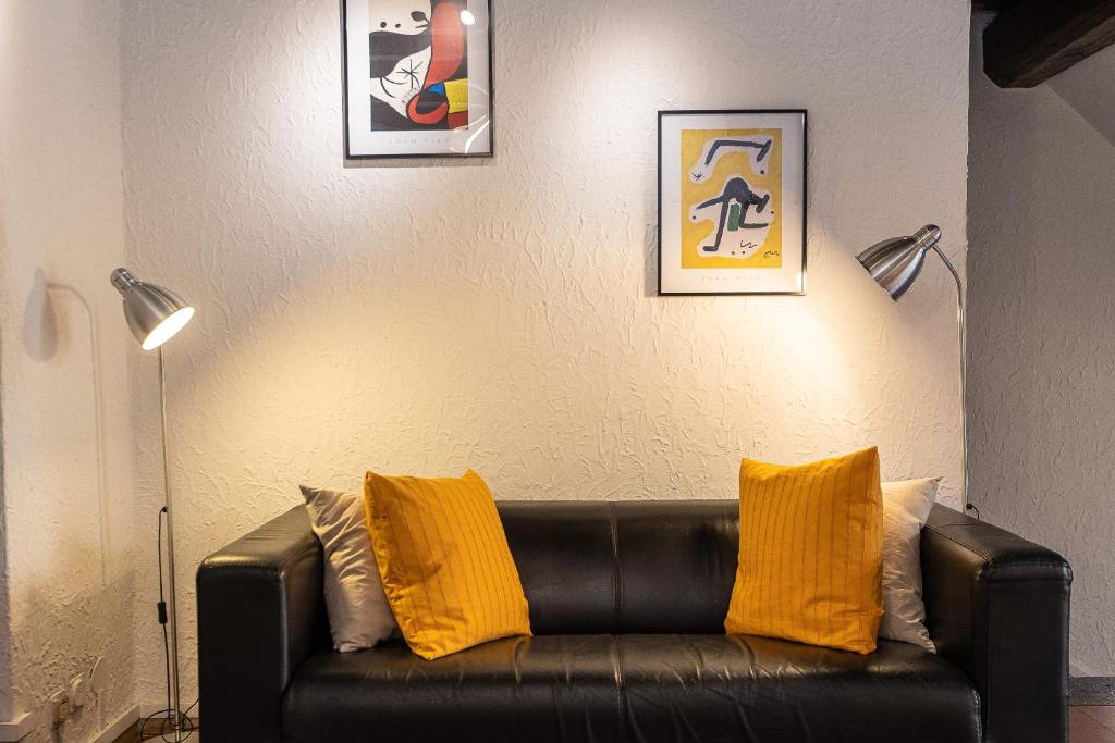 罗马Ciambella Terrace-Rental in Rome的客厅里配有带黄色枕头的黑色真皮沙发