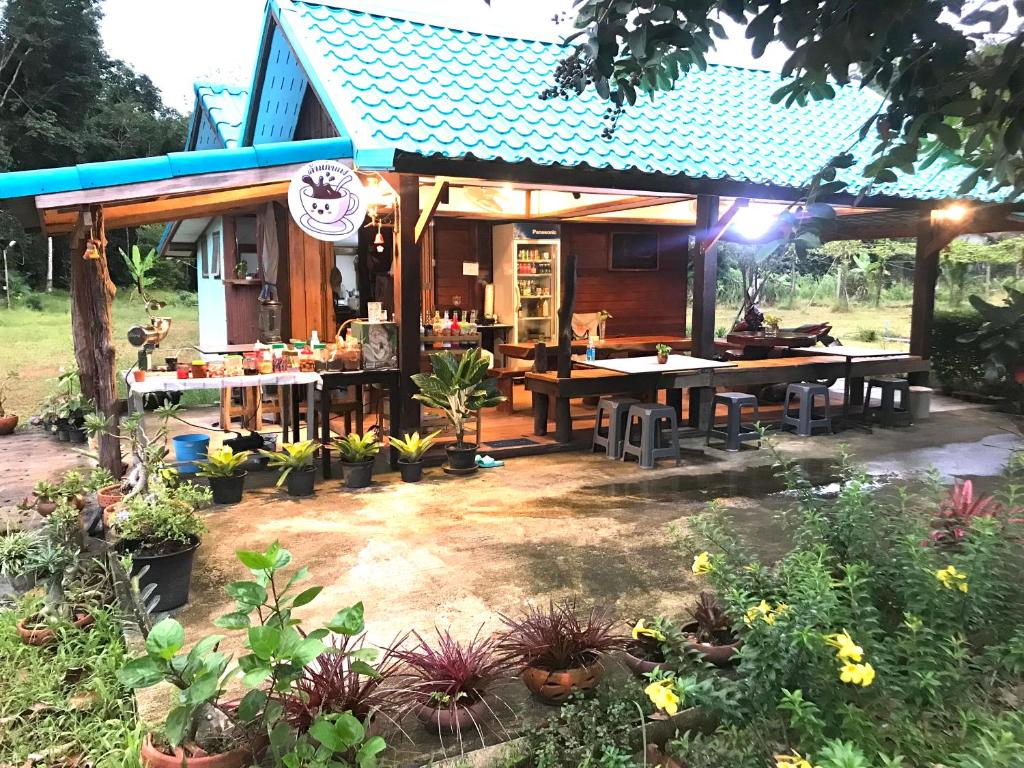 Ban Ao Yaikohkoodfarmstay的一座带桌子和一些植物的房子