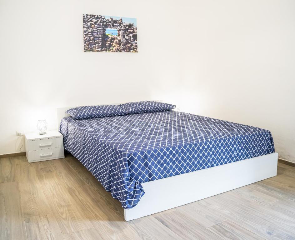 丽都玛里尼Casa al mare Le Dune的一间卧室配有一张带蓝色和白色床单的床。