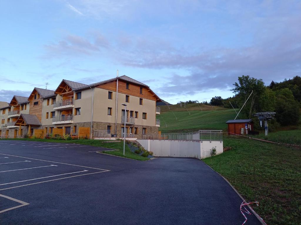 昂塞勒Appartement Les Vallons au pied des pistes的大型建筑前的停车场