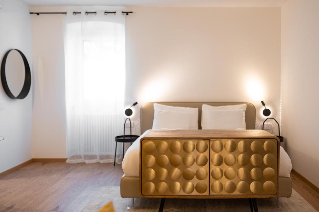 梅拉诺Guesthouse diWINE的一间卧室设有金色床和窗户