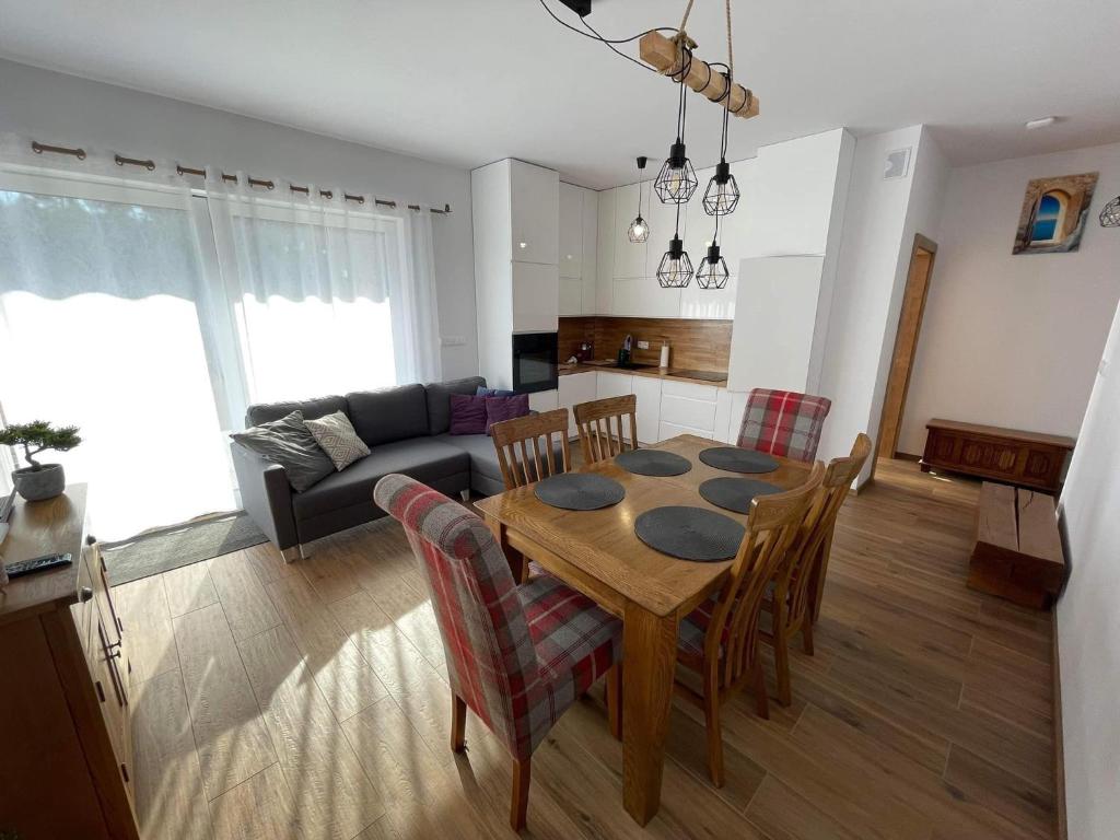 乌斯特卡Luxoro Park Apartament Nero的厨房以及带桌椅的起居室。