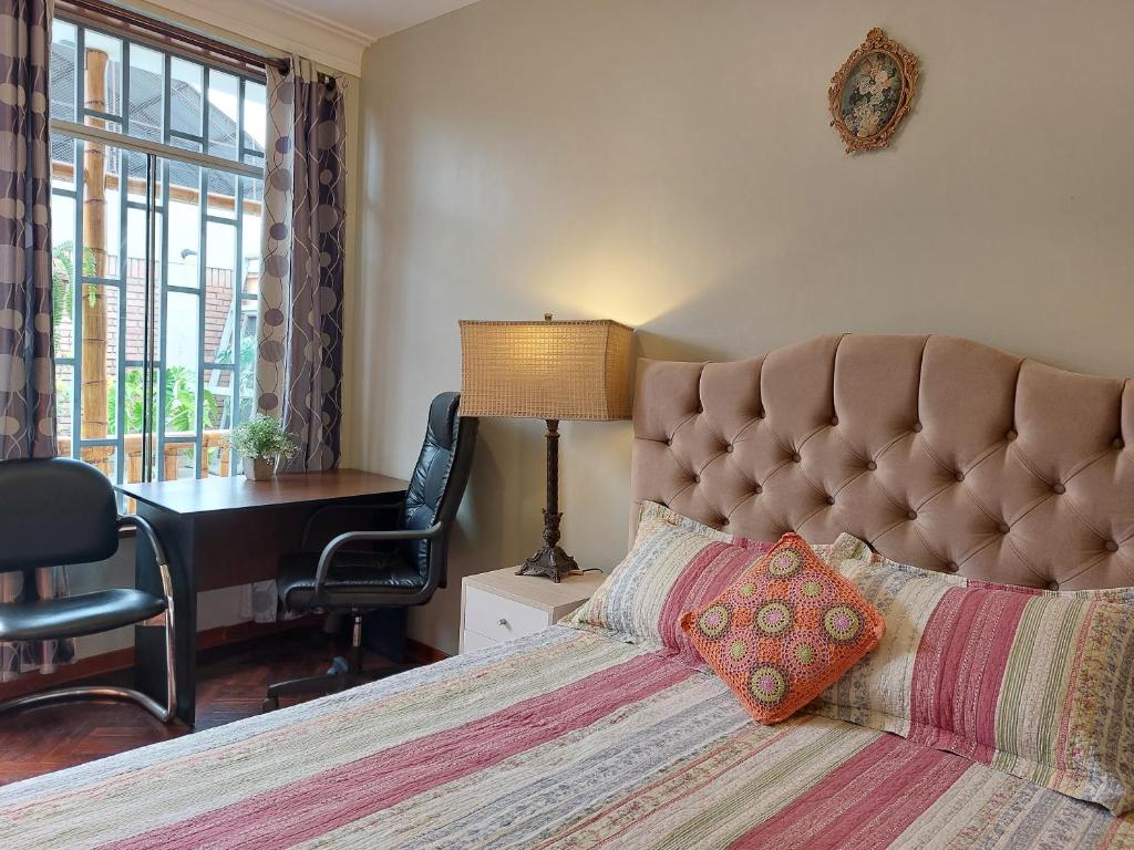 利马Casa Amarello的一间卧室配有一张大床、一张桌子和一把椅子