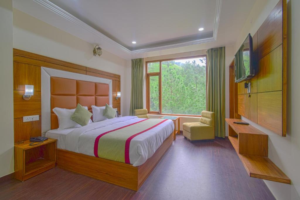 西姆拉Hotel The Paal的一间卧室设有一张大床和一个窗户。