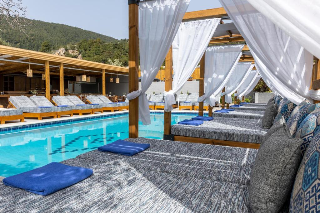 斯基亚索斯镇Skiathos Thalassa, Philian Hotels and Resorts的游泳池旁的一排床