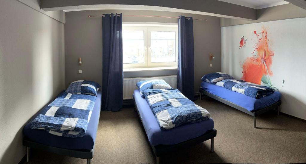 费马恩Hostel Fehmarn Mehrbett-Zimmer的带窗户的客房内的三张床