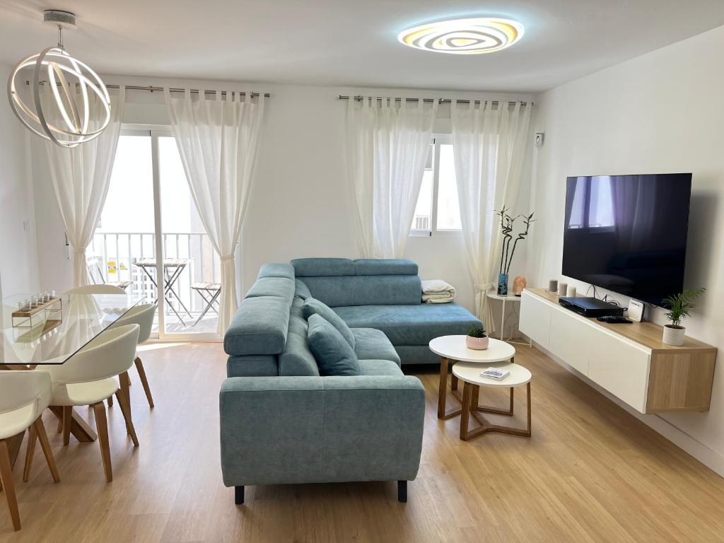 阿尔姆尼卡Casa del olivo的客厅配有蓝色的沙发和电视