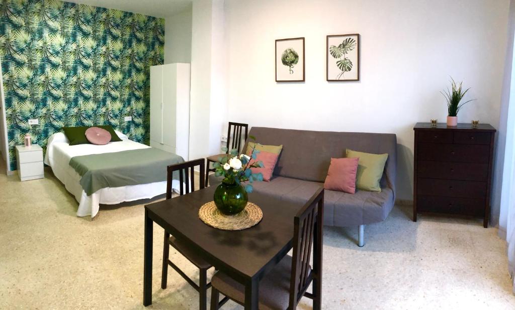 马拉加Apartamento con piscina en Ciudad Jardín的客厅配有沙发和桌子