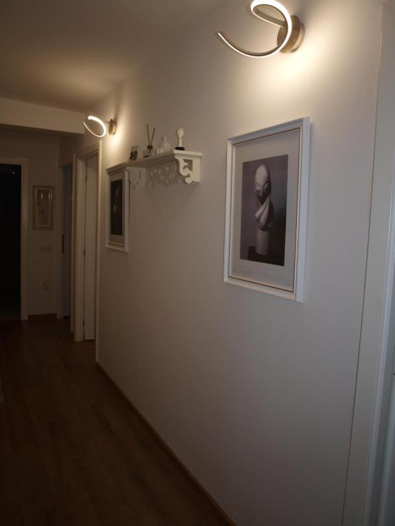 塔古玖Amavera Apartment的白色墙壁上挂着照片的走廊
