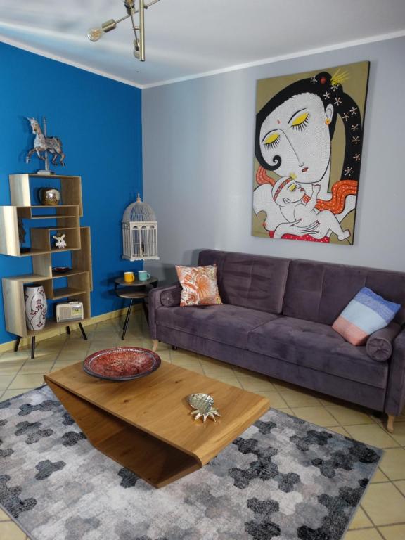 布尔日APPARTEMENTY COCO BOLO的客厅配有紫色沙发和桌子