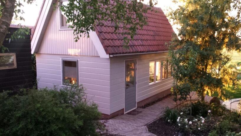 阿姆斯特丹Very nice cottage in Durgerdam, with private garden, free parking, pets allowed的红色屋顶的紫色小房子