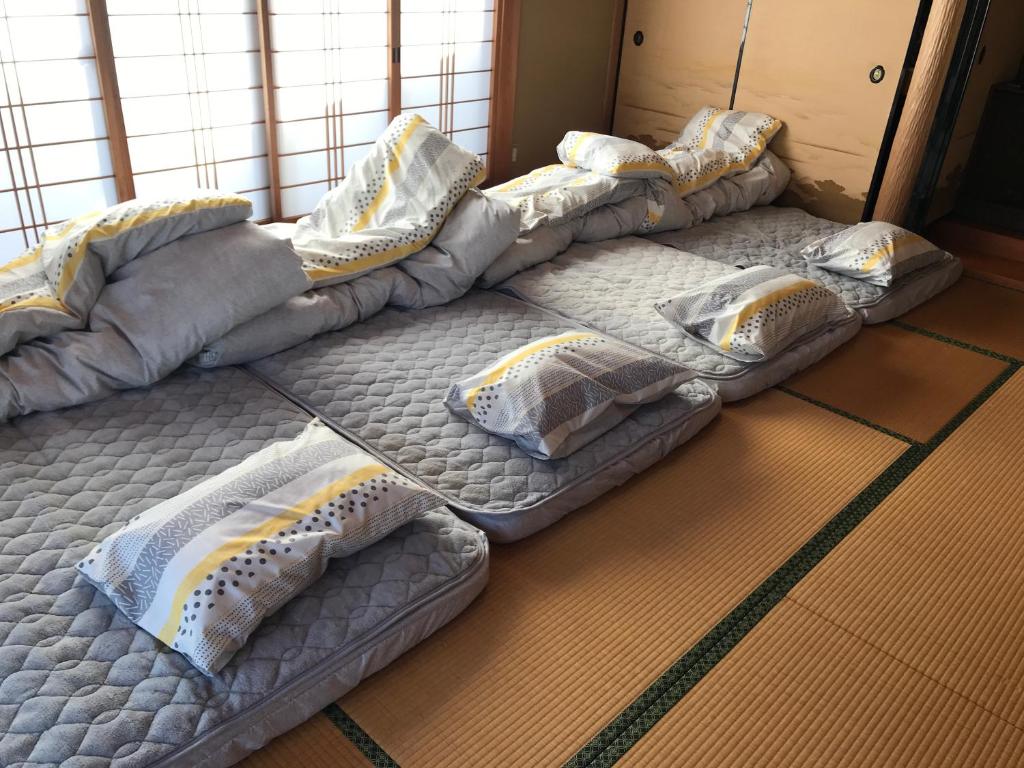 Hutami民泊　二見のおうち的一套床垫在房间内排成一排