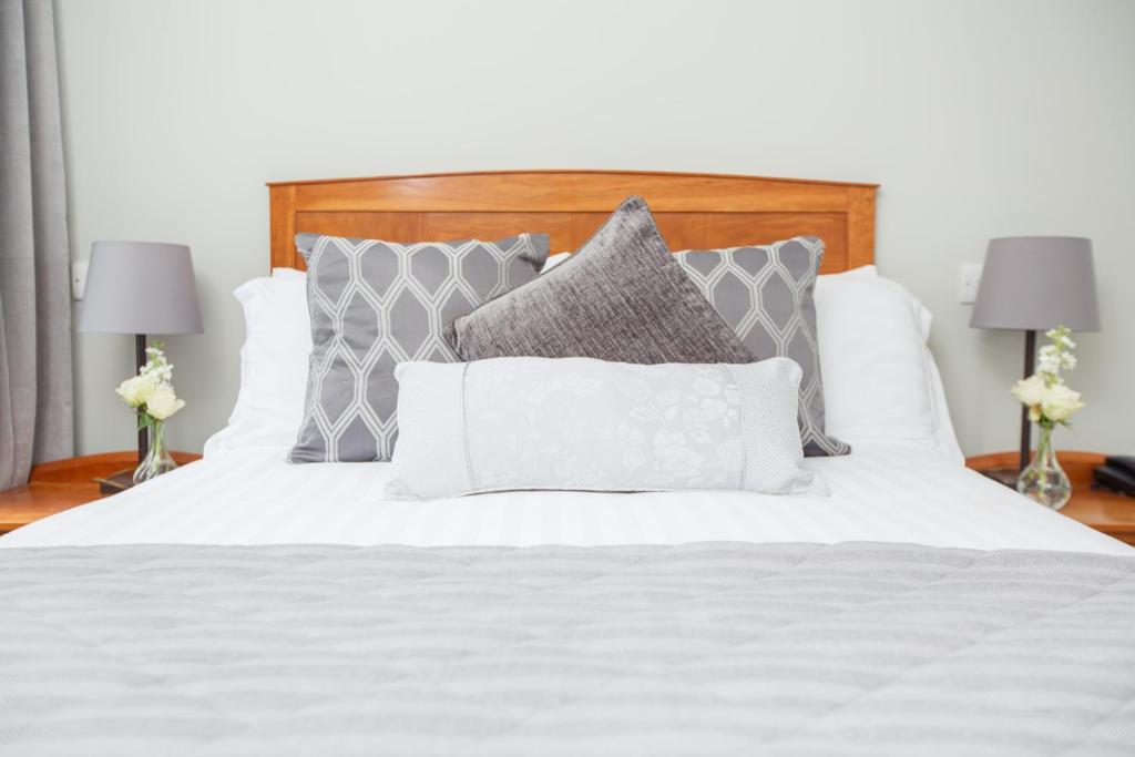 凯尔凯尔克兰洛奇酒店及休闲中心的一张带灰色枕头和白色床单的床