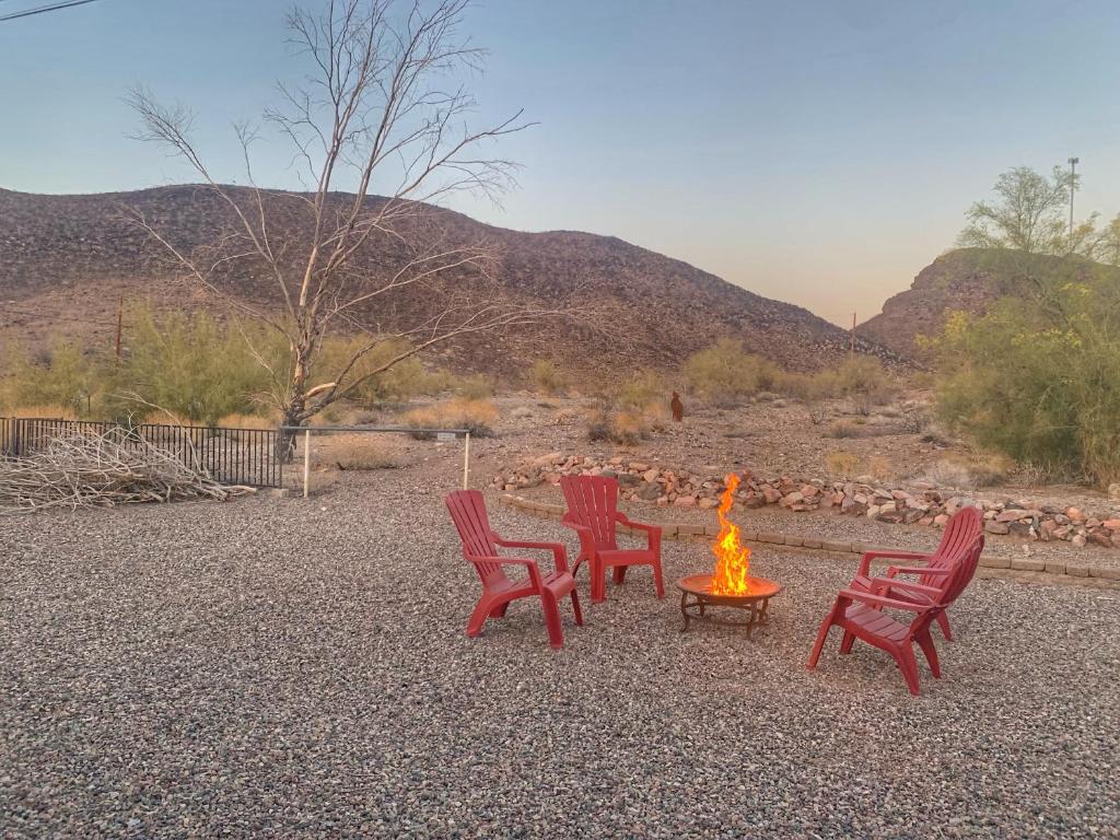 哈瓦苏湖城Desert Getaway - Centrally Located, Trail Access Steps Away!的一组红色椅子和一个火坑