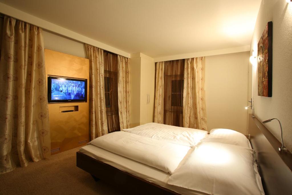 Kraubath an der Mur兰德吉斯霍夫佳家维尔特酒店的卧室配有白色的床和电视。