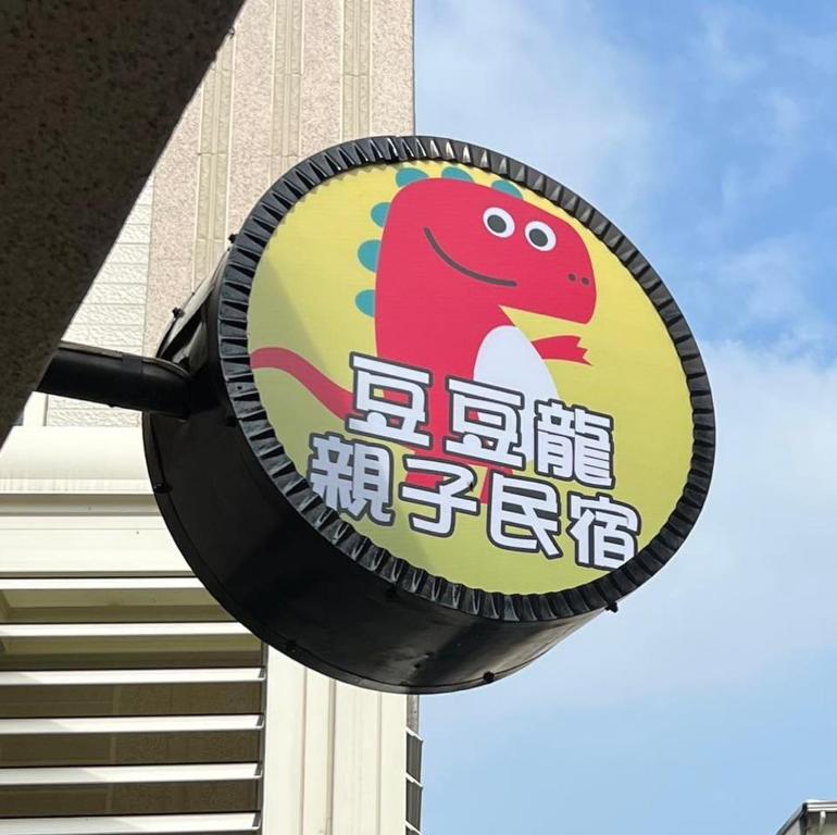 东港豆豆龙亲子民宿 的建筑前的恐龙标志