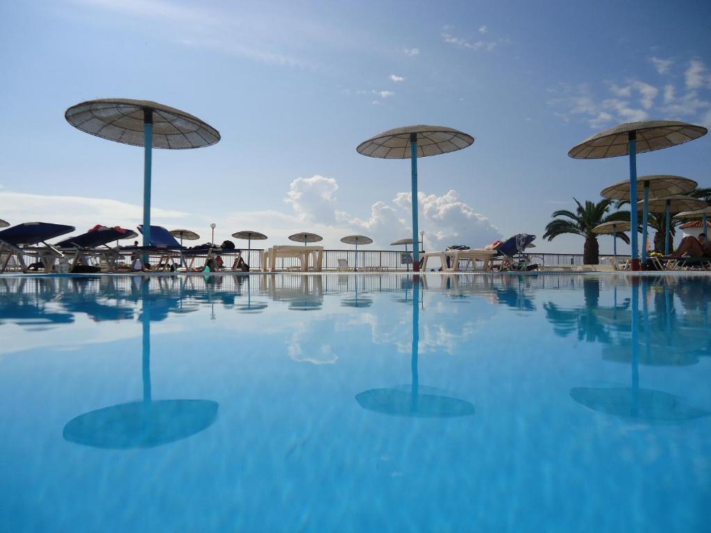 卡沃斯Corfu Sea Gardens Hotel的一个带遮阳伞和桌椅的游泳池