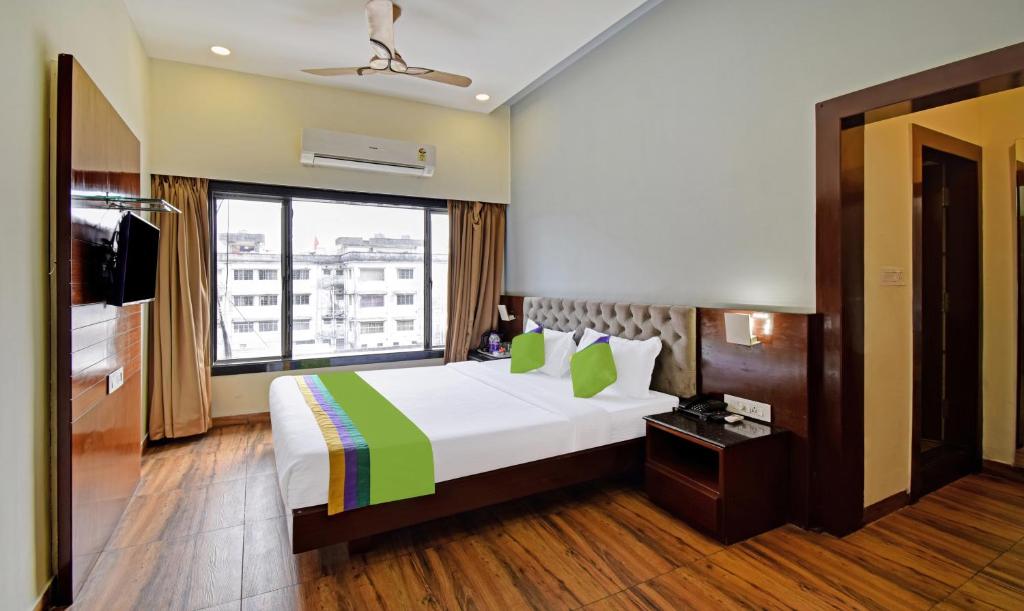 西里古里Treebo Trend Sky Point的酒店客房设有一张床和一个大窗户