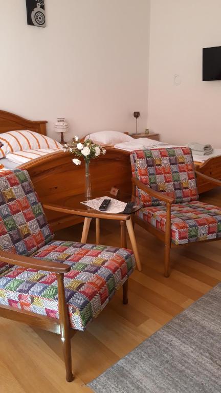 图兹拉Apartment and rooms"Tabašnice"Tuzla centar的一间卧室配有一张床、两把椅子和一张桌子