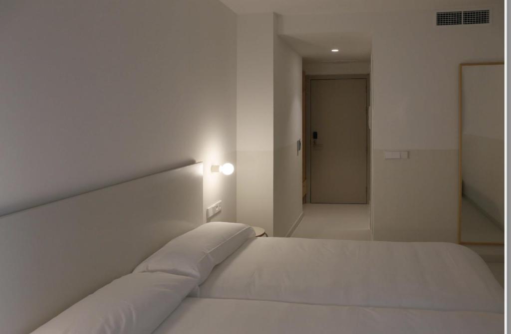 塔拉桑纳阿拉贡HOTEL LA FONDA B&B的白色卧室内的一张白色床,设有走廊