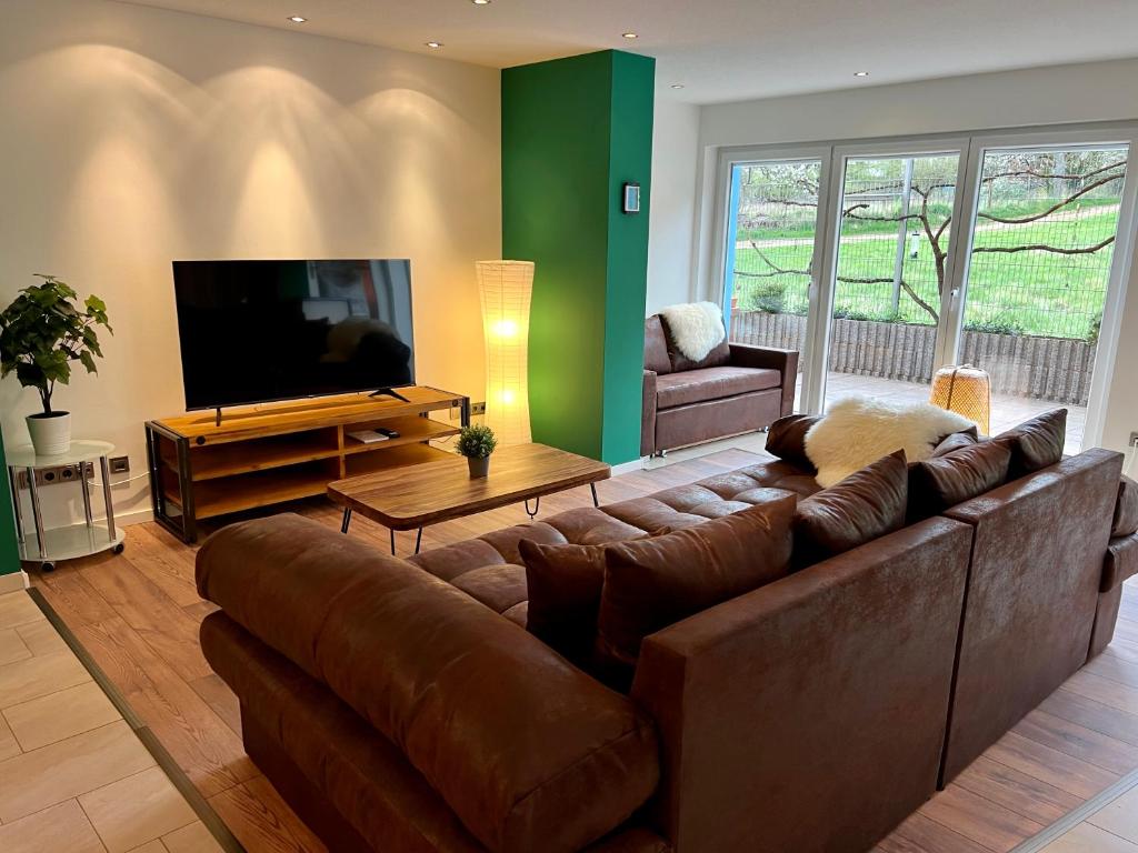 BeckingenJUNIPRO Apartments Haustadt的客厅配有棕色沙发和平面电视