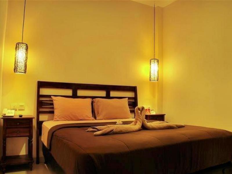 金巴兰天堂椰林之家酒店的一间卧室配有一张带两个灯的大床