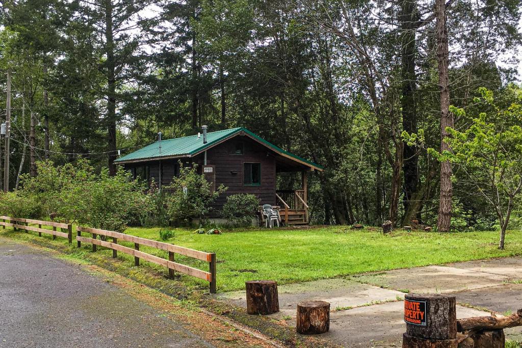 Shelter CoveCove Cabin Retreat的路边树林中的小屋