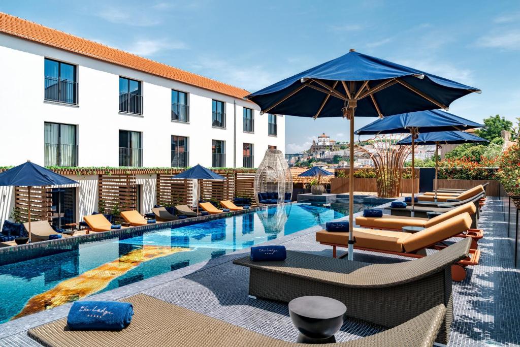 加亚新城The Lodge Hotel的酒店设有带躺椅和遮阳伞的游泳池