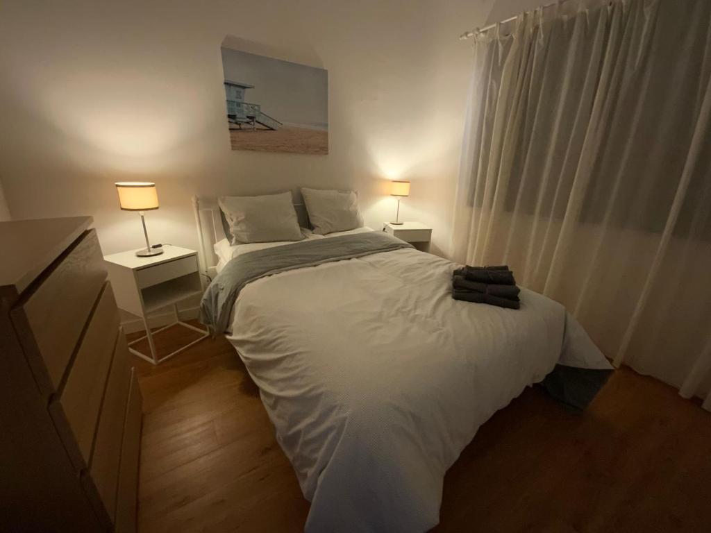 拉加里塔La Garita Bay Apartments的卧室配有带两盏灯的白色床