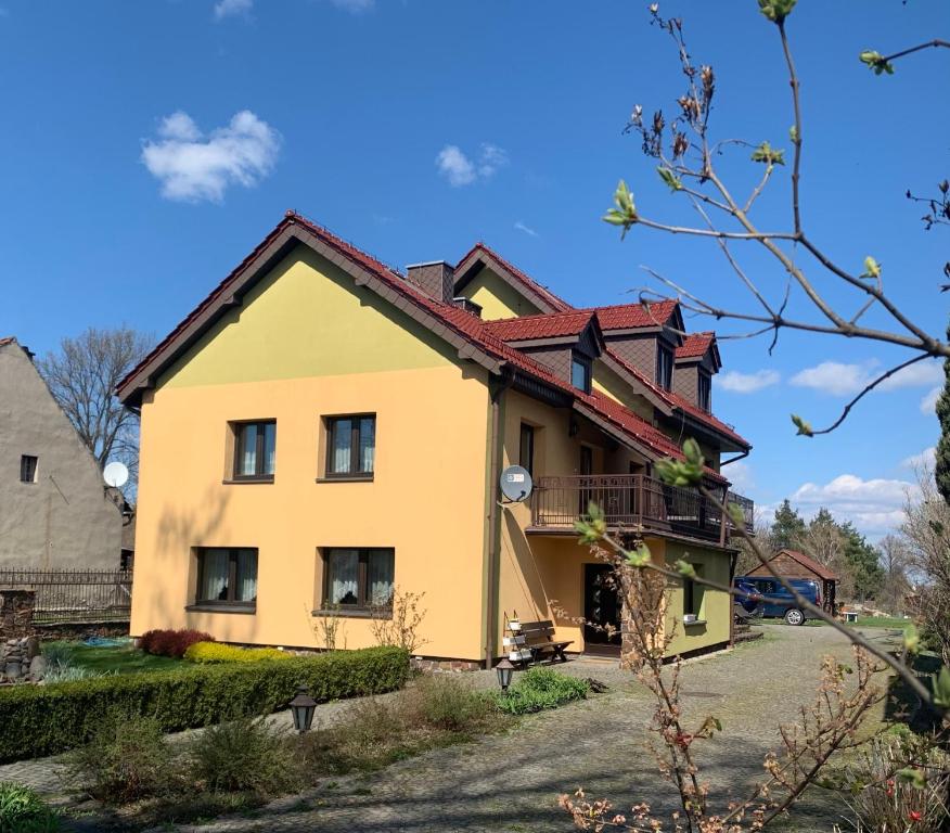 Suchy BórWakacyjny dom w Suchym Borze的黄色的房屋,有红色的屋顶