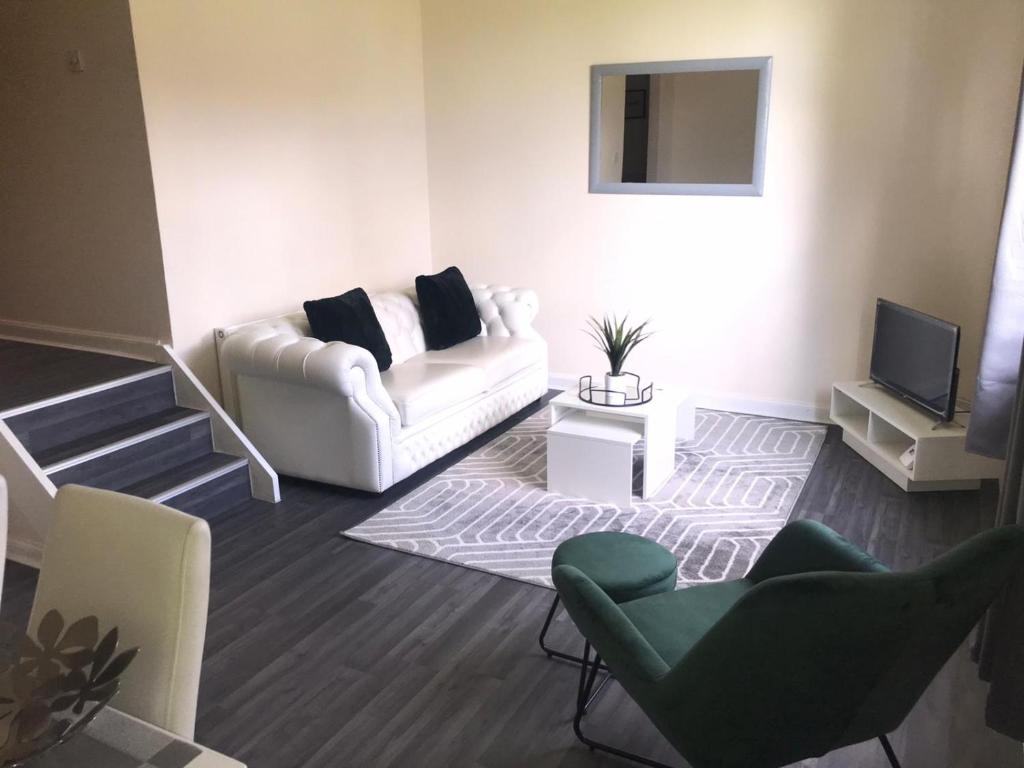 格拉斯哥Vogue Apartments的客厅配有白色的沙发和椅子