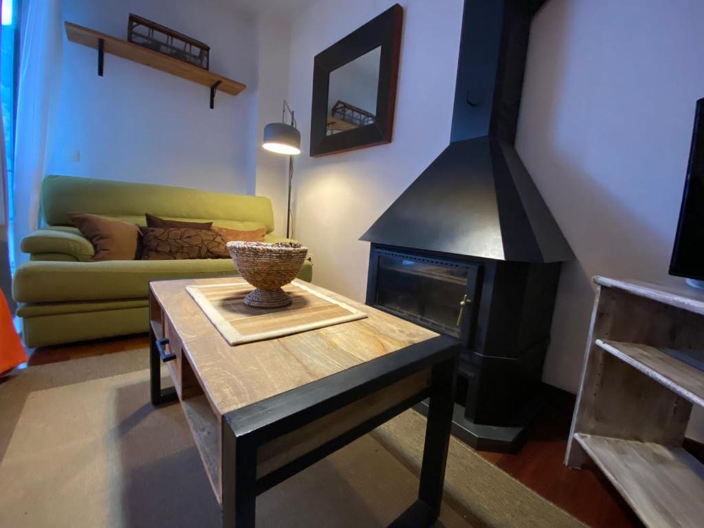 维耶拉Apartamento tranquilo Vielha Centro con Parking Gratuito的客厅配有桌子和壁炉