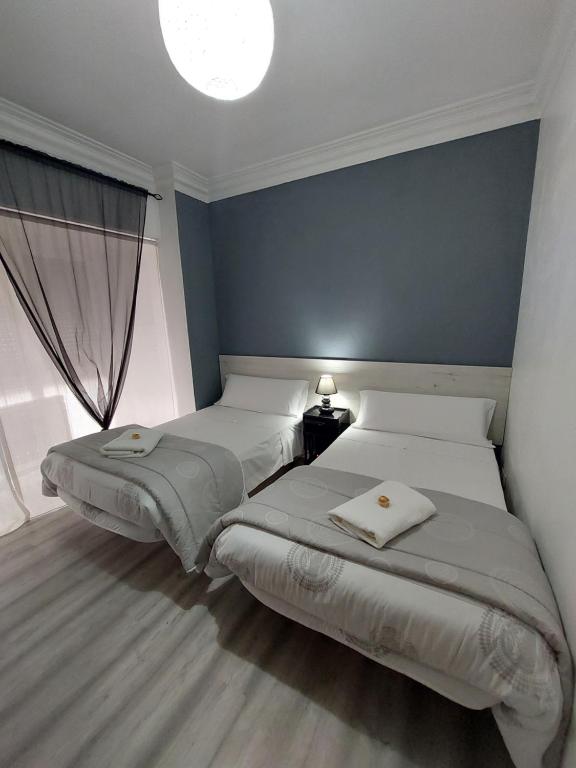 洛格罗尼奥圣马修酒店的一间卧室设有两张床和窗户。