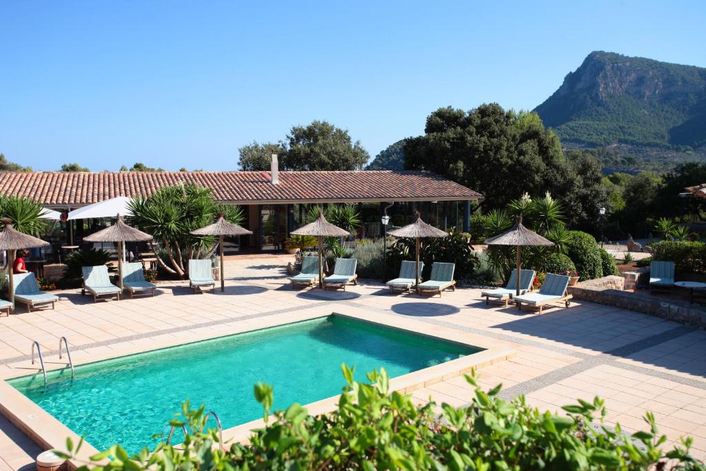 巴尔德莫萨Ca's Garriguer的度假村的游泳池,配有椅子和遮阳伞