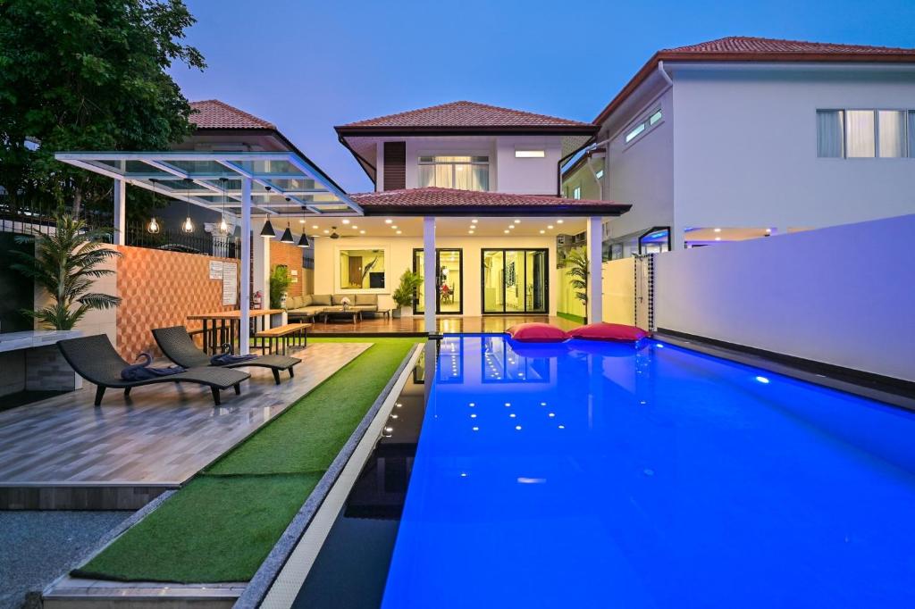 南芭堤雅4BD Pool Villa Pattaya with Jacuzzi - Exquisite Pool Villa A的一座房子后院的游泳池