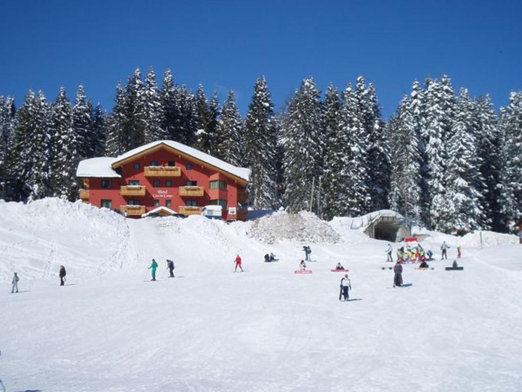 摩德纳迪-坎皮格里奥卡萨坎波酒店的一群人,在滑雪小屋前的雪中